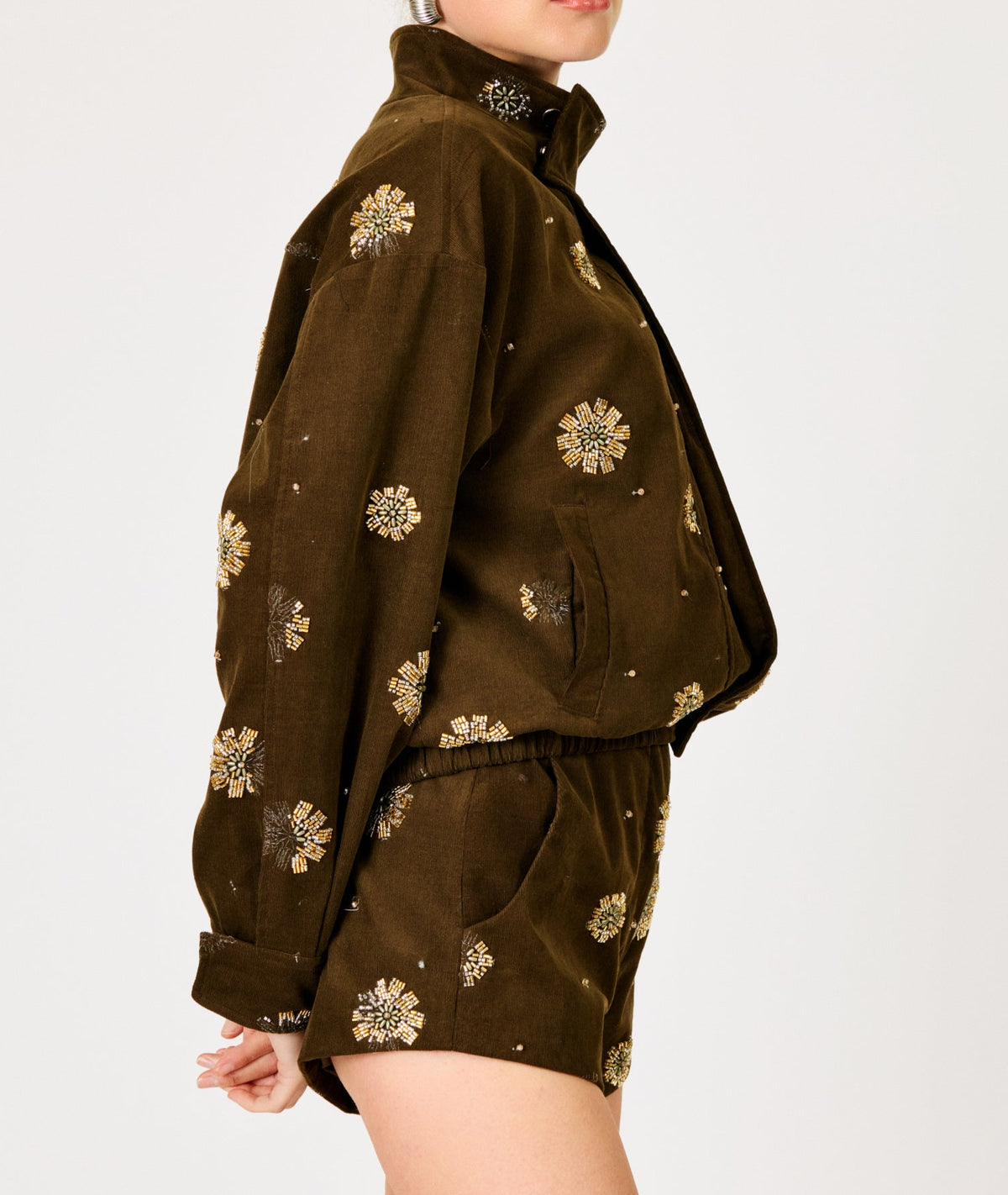 Woman wearing a brown outfit with floral patterns on a white background