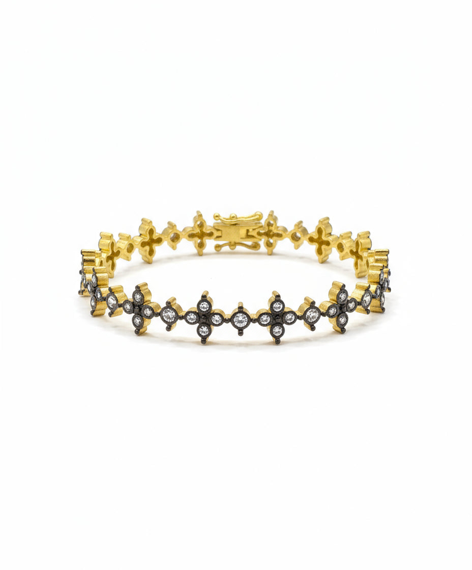 Gold bracelet with star designs on a reflective surface, featuring a price tag.