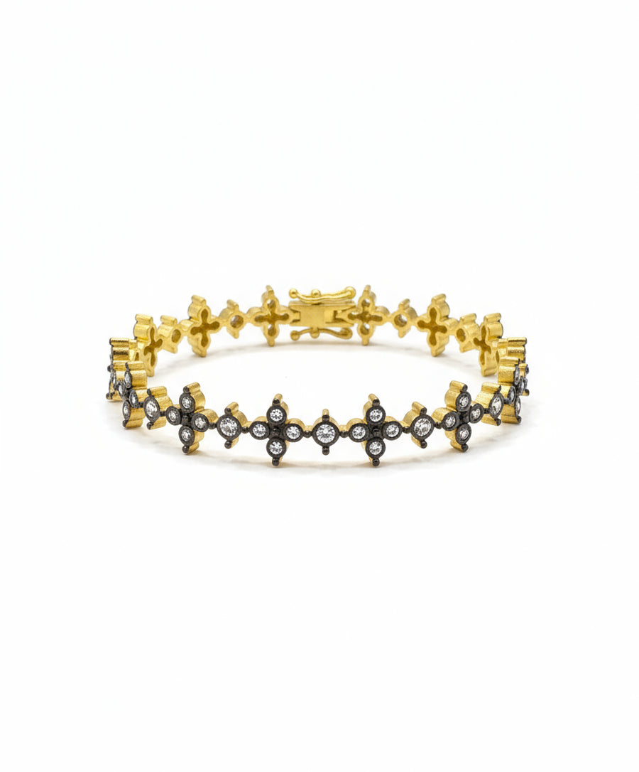 Gold bracelet with star designs on a reflective surface, featuring a price tag.