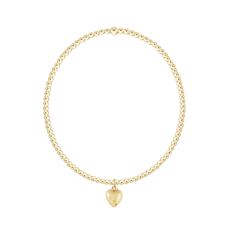 Gold beaded necklace with a heart-shaped pendant on a white background