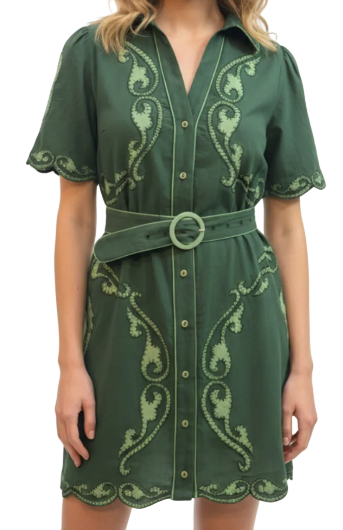A green short-sleeve button-front dress with light green embroidered scroll motifs, a matching belt with a round ring buckle, and scalloped edges, shown on a model against a plain white background.